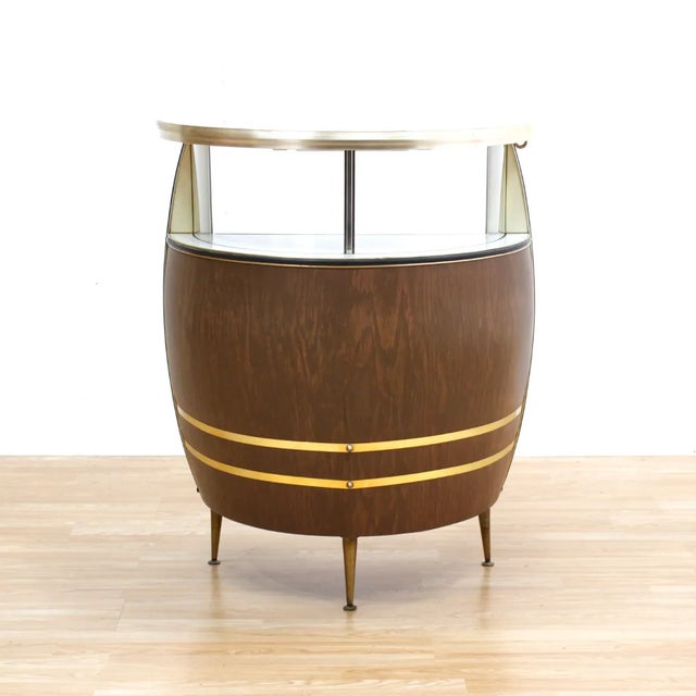 This mid-century bar was produced in England during the 1960s. A vintage home bar with formica and metal detailing in the...