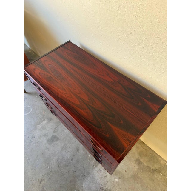 Striking Mid Century Modern Danish chest of drawers crafted in richly grained rosewood, showcasing dramatic bookmatched...