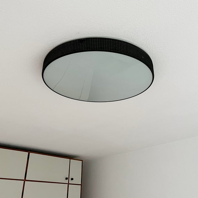 A ceiling light from hillebrand leuchten model 1135/511 150463. black perforated sheet with frosted glass pane. equipped...