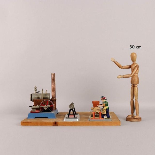 Model of a steam boiler with iron elements fixed on a wooden support. Manufacturer labels applied. This piece is...