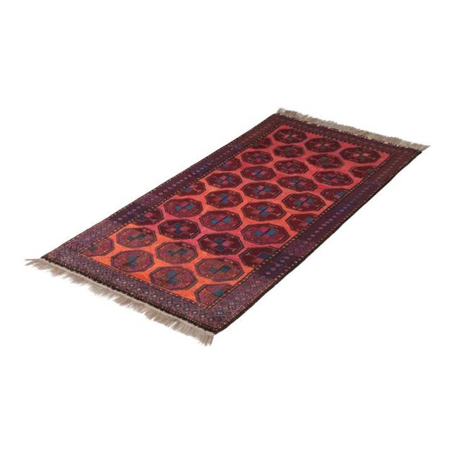 Hand-knotted in wool originating circa 1920-1930, this antique Persian rug connotes a transitional Baluch rug design of...