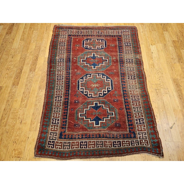 This vintage Caucasian Kazak area rug from the late 1800s features the classic four-gul design — a revered and ancient...