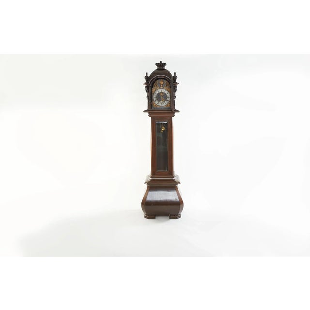 Mid 18th century walnut wood framed German 8-Day Grandfather clock. The tall case clock featured a dark walnut case with...