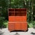 A versatile Danish Modern two-piece teak storage cabinet that combines open shelving, concealed storage, and a built-in...