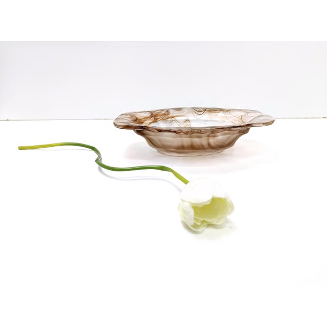 Made in the UK by George Davidson, 1940s. This large oval bowl is made in sepia calcedony glass and features a rippled...