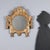 Small mirror in finely carved wood, decorated with neoclassical motifs and gilded in mecca, exemplifies the artistic...