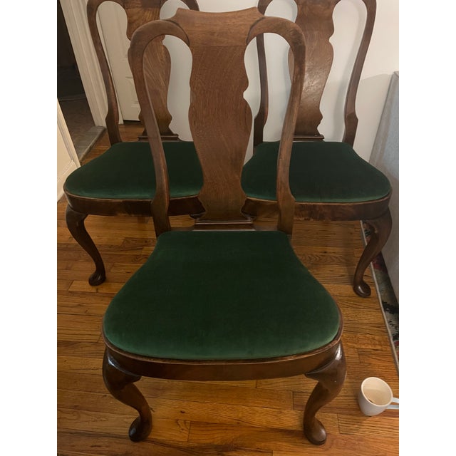 Set of 3 Queen Anne-style dining chairs. Walnut-shade finish on the wood and green velvet upholstery. The upholstery is...