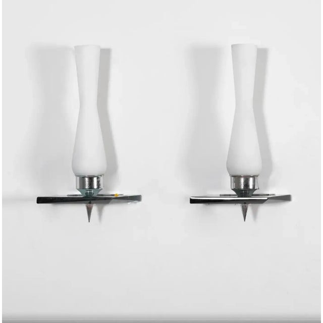 Two high quality wall sconces designed and manufactured in Italy in the Sixties. Chromed steel, heavy glass and white...