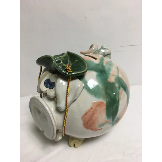 One of a kind , hand thrown adorable piggy bank in soft greens and peach, blue eyed, wearing a bonnet . Pristine condition...
