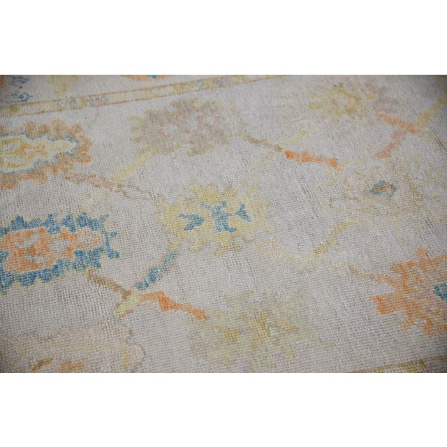 This modern Turkish Oushak rug is a stunning piece of art that has been handwoven using traditional techniques by skilled...