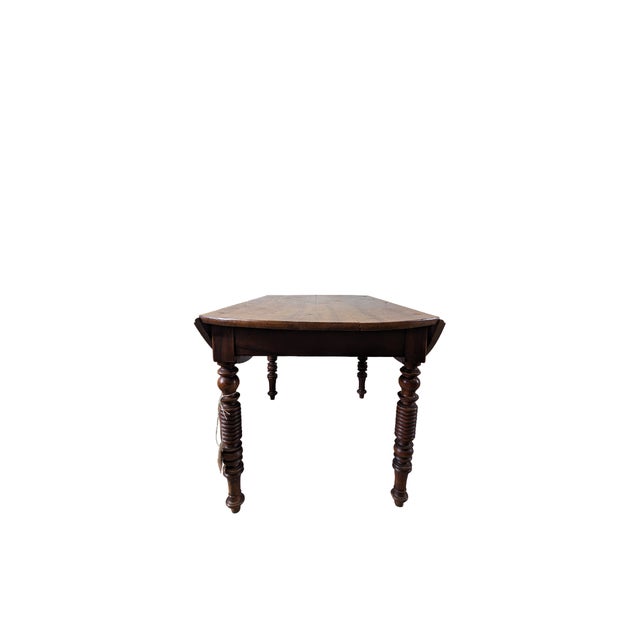A vintage table dating back to the 19th century, crafted from fine walnut. The piece features sides that can be opened and...