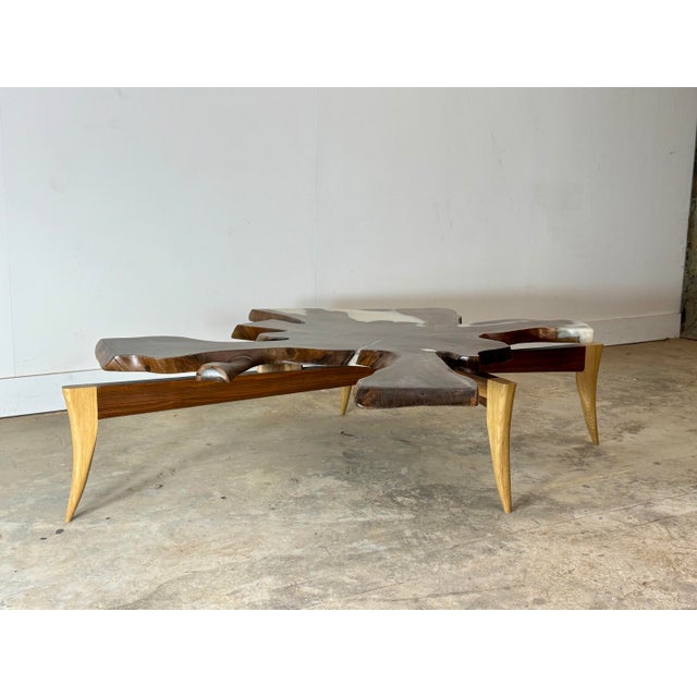 The Rootspan Coffee Table is a striking sculptural centerpiece crafted from a cross-cut section of a walnut tree root,...