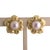A pair of earrings crafted from 18k yellow gold. The design features a central pearl surrounded by intricately detailed...