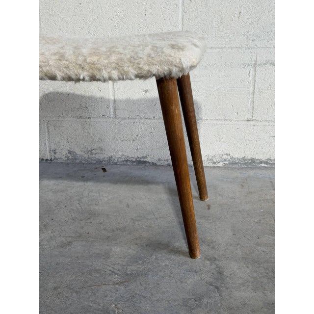 Vintage Danish Mid Century Modern vanity stool featuring elegant tapered teak legs and upholstered sheepskin-style fabric...