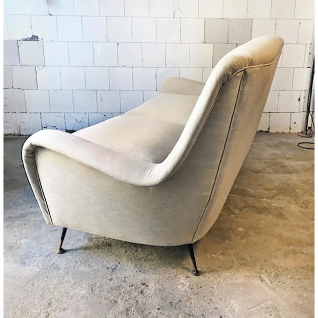 Two seater sofa upholstered with wooden frame and brass legs. Italian Production 50s