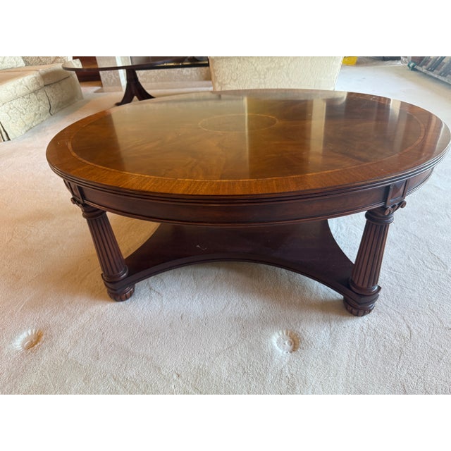 A beautifully executed Neoclassical-inspired coffee table by Henkel Harris, featuring a richly figured mahogany top with...