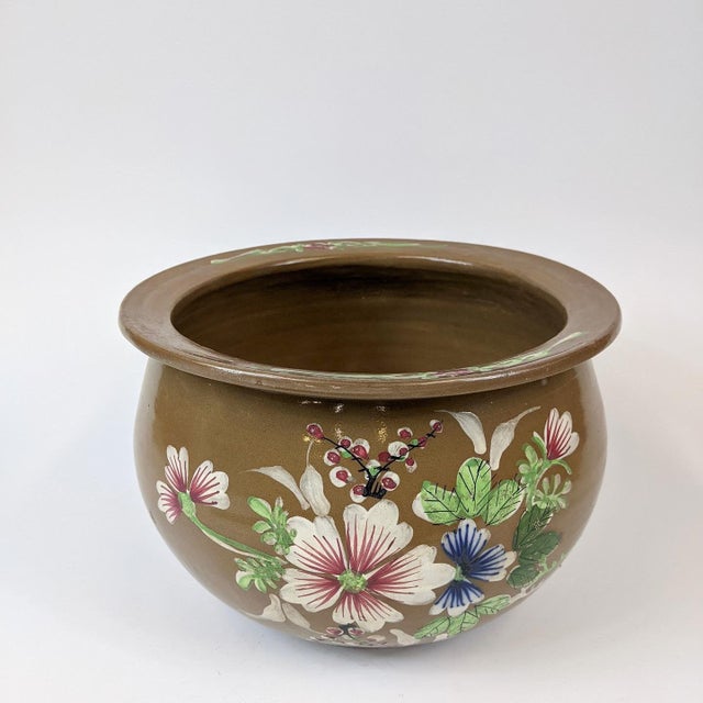 This lovely and unique brown planter is from the 19th Century. The flowers are hand painted and the characters on the back...