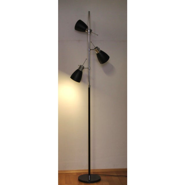 This floor lamp was designed in France in the 1960s. It consists of three black lacquered shades as well as chrome-plated...