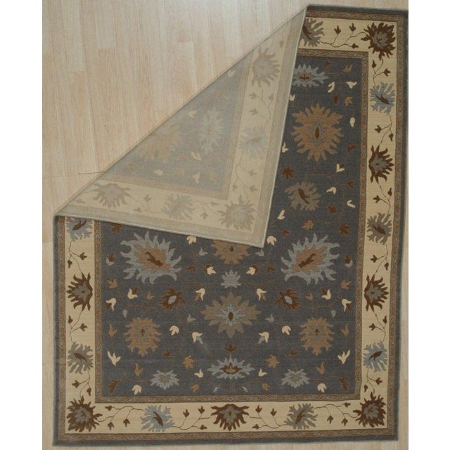 This hand knotted pile rug features a classic Oushak style design rendered in a primary gray color. Crafted from wool,...