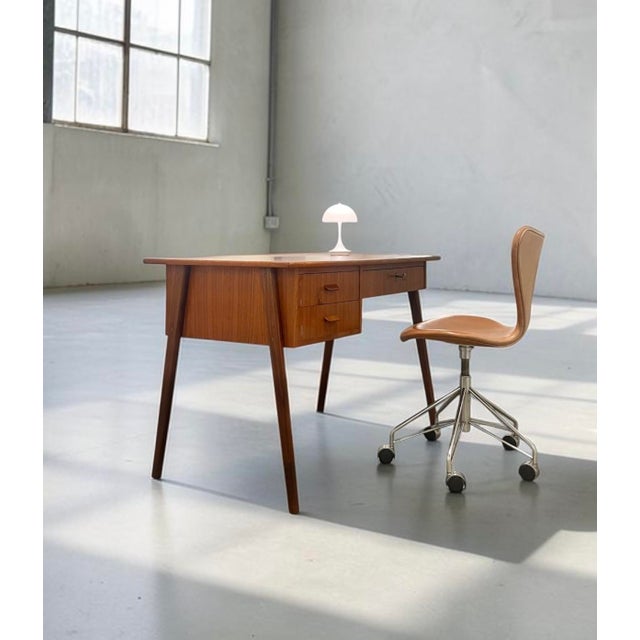 Petite freestanding writing desk crafted by a danish cabinetmaker, denmark, c. 1960s. executed in teak with a sculptural...