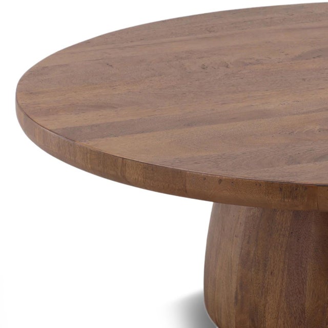 Modern tropical style warm solid mango wood coffee table with round top and pedestal base. Simple clean design and easily...