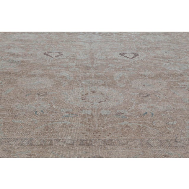 A Persian Tabriz rug, the honey field a subtle allover trellis of voluptuous feathery leaves, palmettes and flowering...