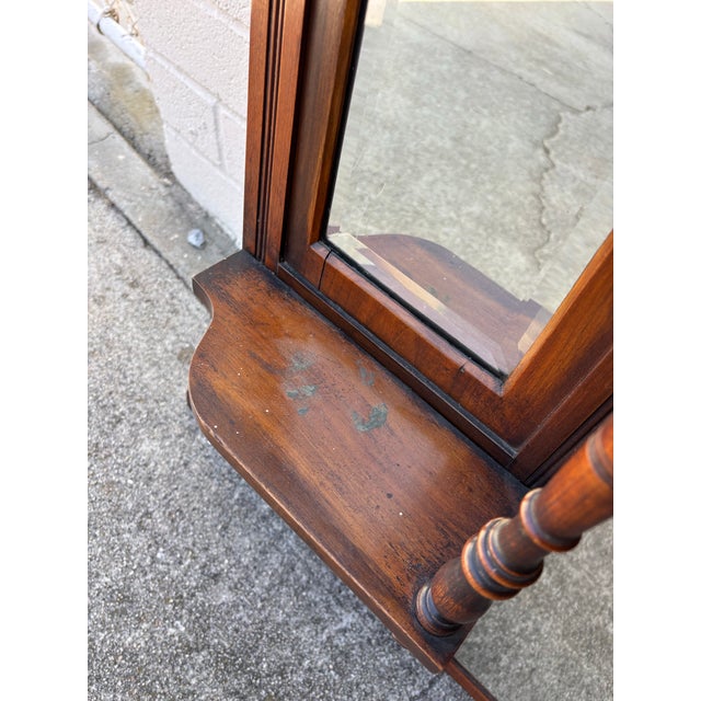 Antique Victorian or Eastlake-style carved wood overmantel mirror featuring multiple bevelled glass panels and display...