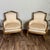 This mid-century vintage pair of Directoire-style bergère armchairs features a wood frame (possibly walnut or fruitwood)...