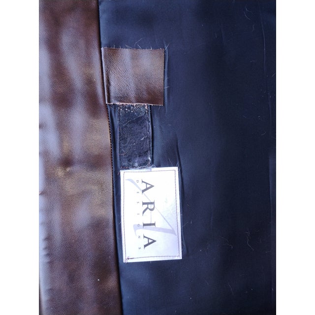 Indulge in the Rich Heritage and Exquisite Craftsmanship of the Aria Leather Chair and Ottoman Set. For Sale - Image 10 of 12