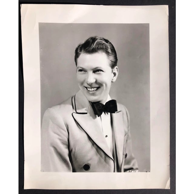 1935 black and white photograph of trumpeter, singer and movie star Johnny Davis (1910-1983) smiling in a fancy 1930s tuxedo.