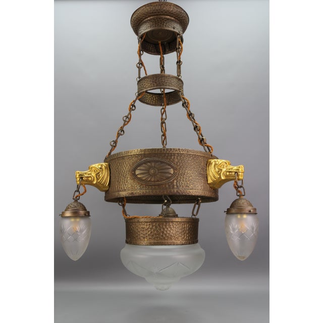 - German Art Deco four-light metal and frosted glass chandelier with dog heads from circa the 1930s. - This imposing Art...