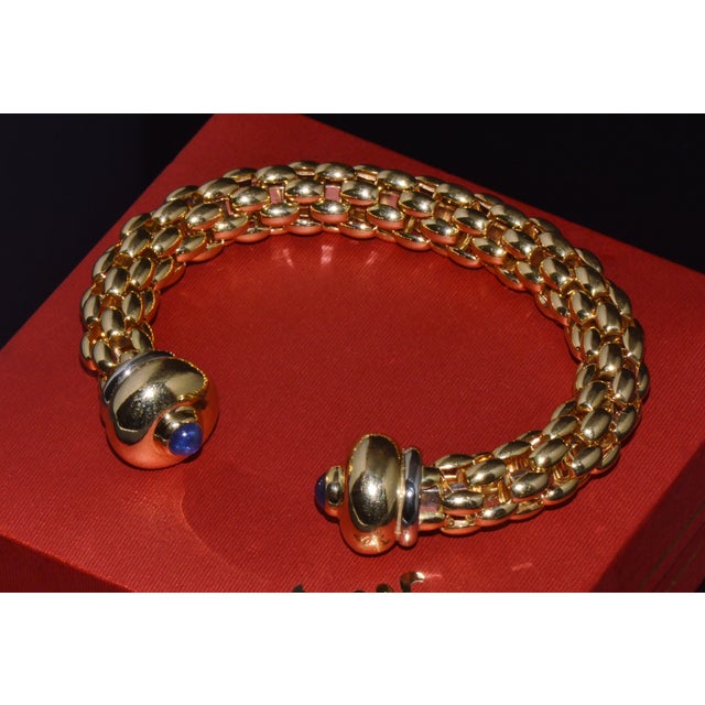Authentic vintage FOPE Flex'it solid 18K gold natural blue sapphire open cuff bangle bracelet. This exceptional designer...