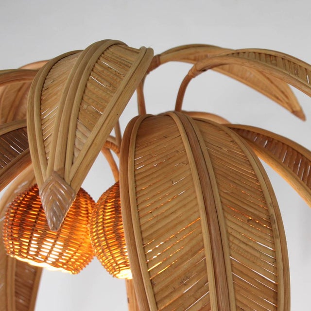 Stunning rattan floor lamp in the shape of a coconut palm. It features 10 removable fronds (convenient for transport) and...
