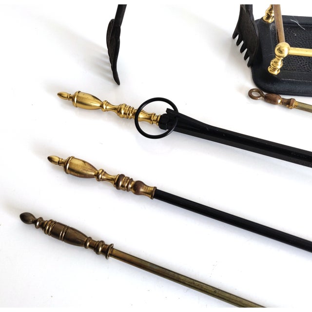 A five piece set of cast iron and brass fireplace tools and a rack to store them. The set has been heavily used and has...