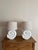 A sculptural pair of plaster seashell table lamps designed in a spiral shell form, finished in a soft matte white with...