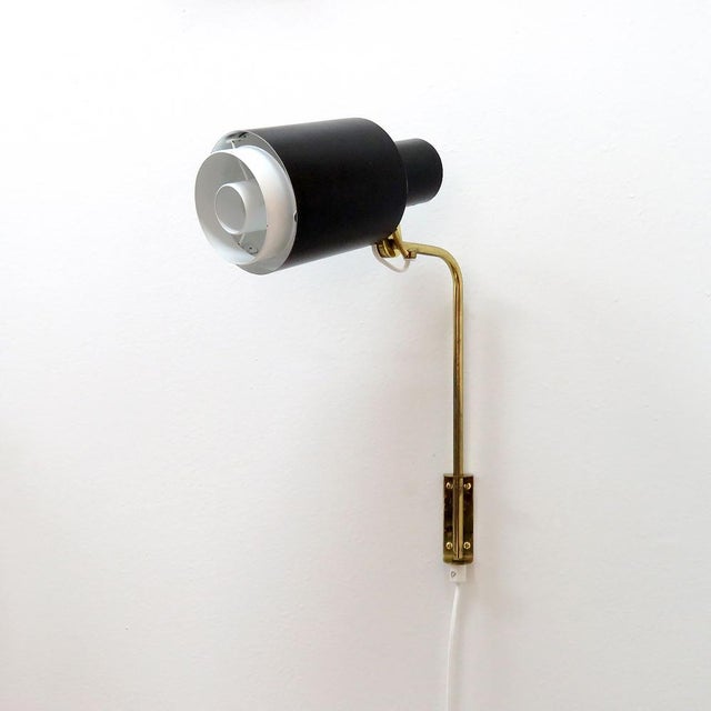 Elegant articulate plug-in wall light by Itsu, Finland, 1960s, black double-tier body with white detachable diffusor at...