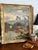 A handsome 19th-century oil on canvas depicting an atmospheric river landscape with a stone bridge, wooded banks, distant...