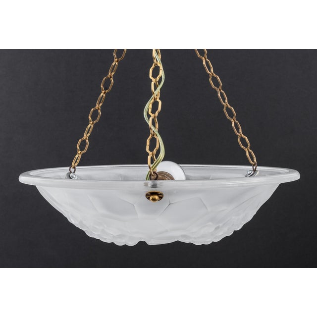 A beautiful pair of Art Deco bowl chandeliers. The shades are frosted white glass with floral motifs. Each shade is signed...