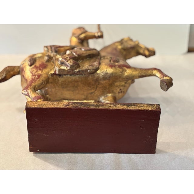 Vintage Chinese warrior on horse with weapons in both hands, gilded wood on base, one leg up on the horse. Beautiful...