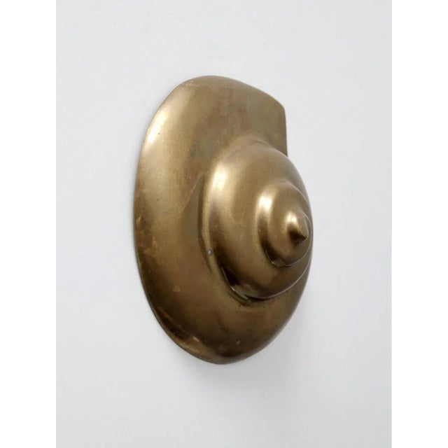 This is a mid 20th century seashell shaped brass wall embellishment. The rich brass tone of the moon shell will make an...