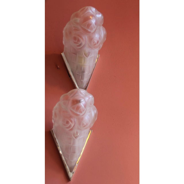 Art Deco wall lights with geometric floral motifs in the glass. The metal is re-nickeled brass. Designed and produced by...