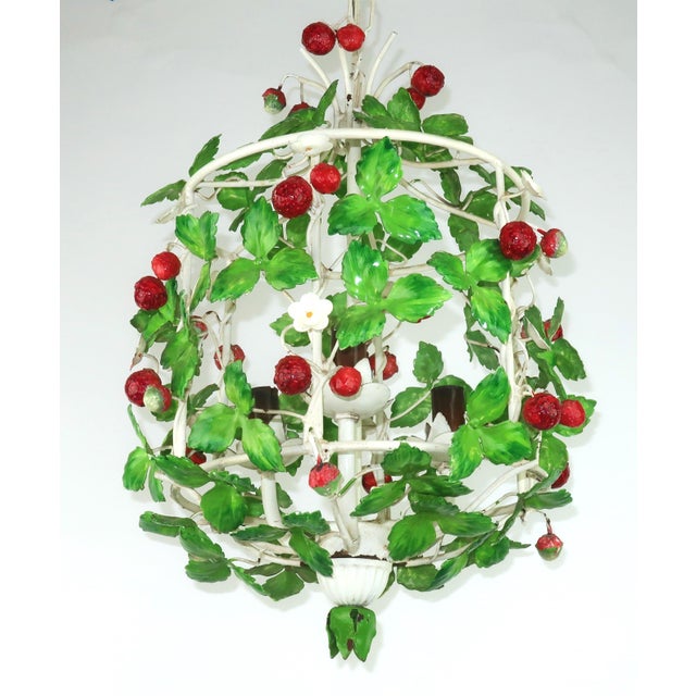 Charming 1960's Italian tole strawberry chandelier in a birdcage shape. The hanging light sports three chandelier bulb...