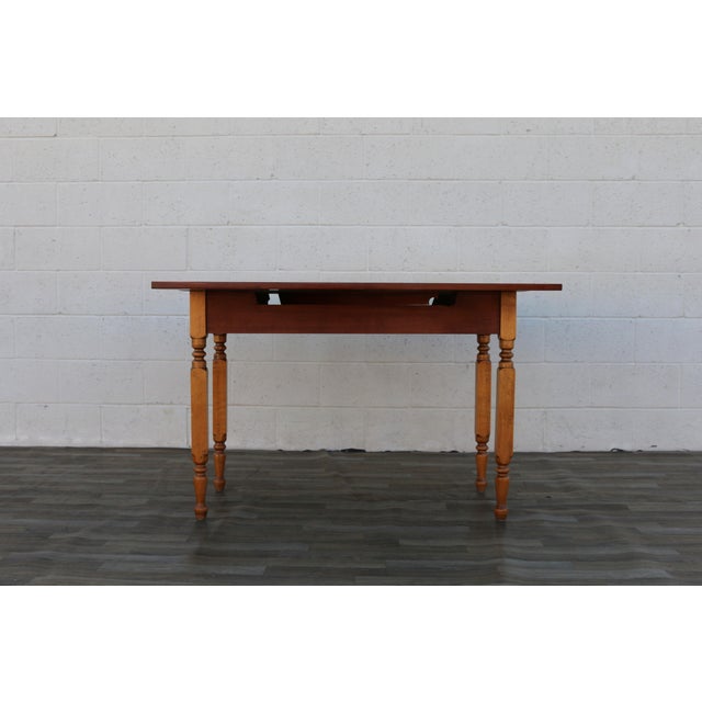 Beautiful antique farmhouse drop-leaf dining table dating to circa 1920s, crafted from wood and featuring a warm,...