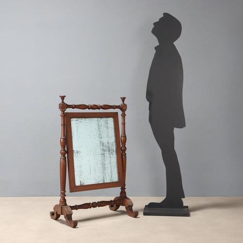 A free-standing walnut psyche. Tilting mercury mirror supported by two turned columns joined by turned crosspieces, with...