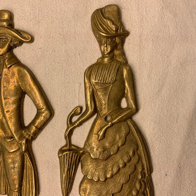 These vintage solid brass Victorian-style figures depict a gentleman with a dog and a lady with an umbrella, commonly used...