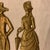 These vintage solid brass Victorian-style figures depict a gentleman with a dog and a lady with an umbrella, commonly used...