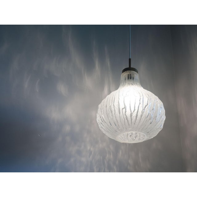 Vintage pendant lamp from Denmark. Designer and manufacturer unknown, estimated 1960s. This lamp is made from a rippled...