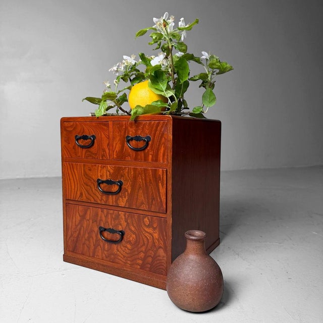Small Japanese drawer cabinet from the 1970s–1980s, with a warm reddish-brown wood colour and a lively, decorative grain....