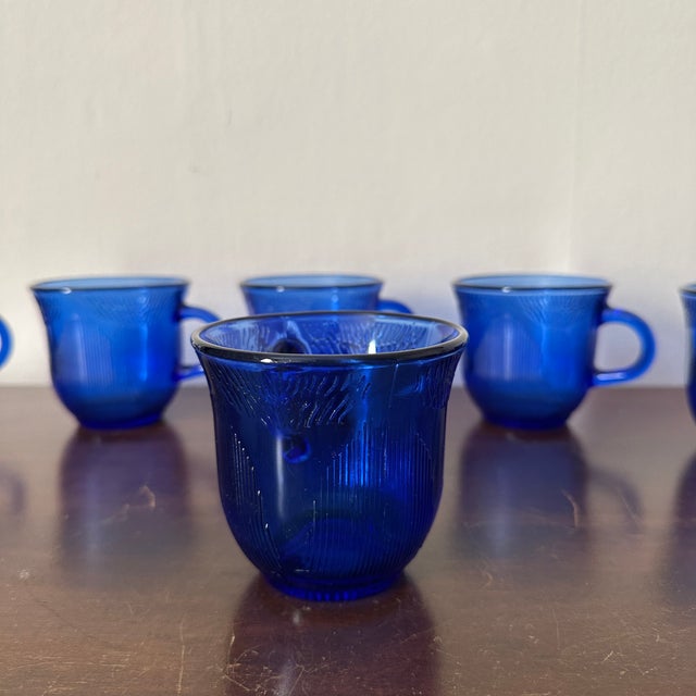 Vintage 1950s cobalt blue glass coffee mugs in a sunflower design produced by Forte Crisa in Mexico.
