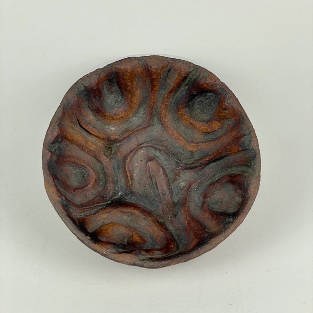 A wonderful small ceramic bowl vase with minimal exterior but canyon like design on the interior. it's artistically...